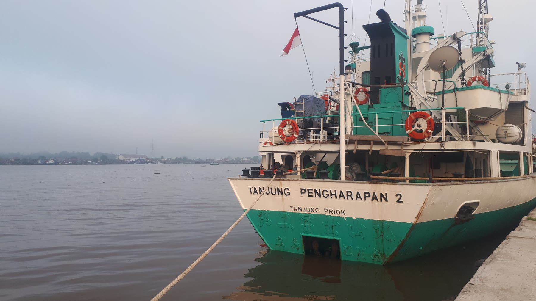 A green-and-white Indonesian vessel moored on the Mahakam River at Samarinda